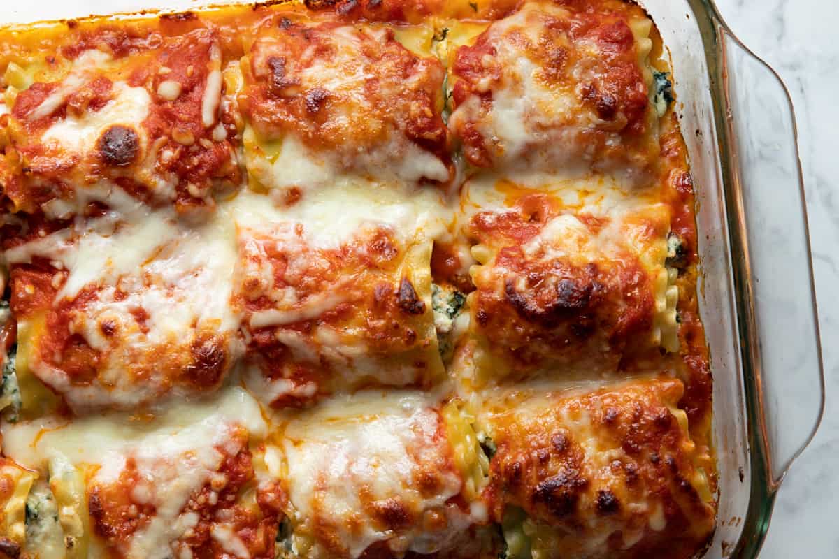 Lasagna rolls with spinach fully baked in a glass dish. 
