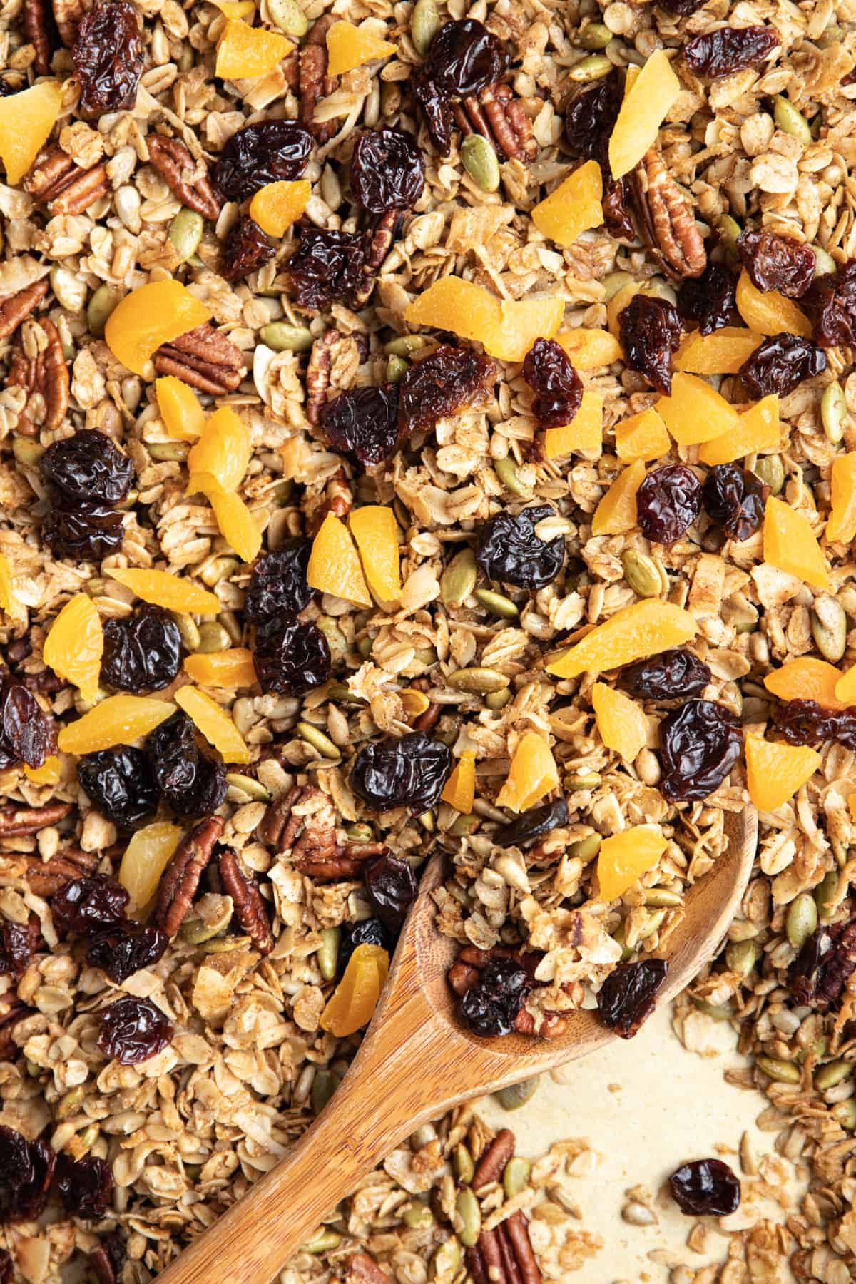 granola on sheet pan with dried cherries and cut apricots on top