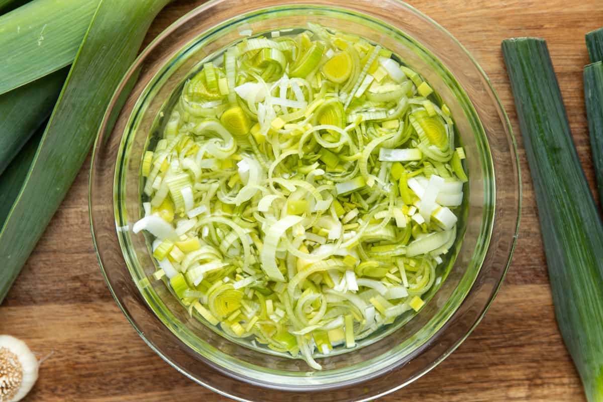 sliced leeks in a clear bowl of water 