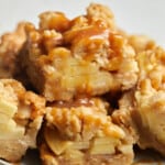 Salted caramel Apple pie bars stacked on white plate.