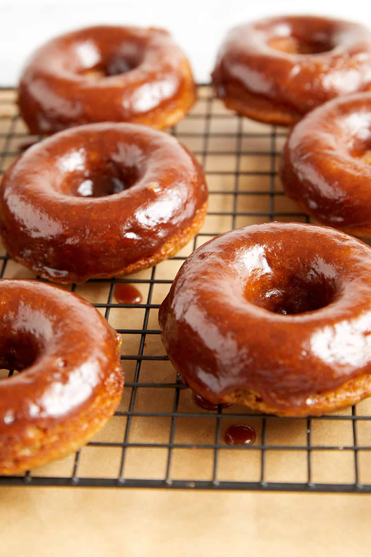 apple cider donuts with apple butter glaze on a cooling wire rack