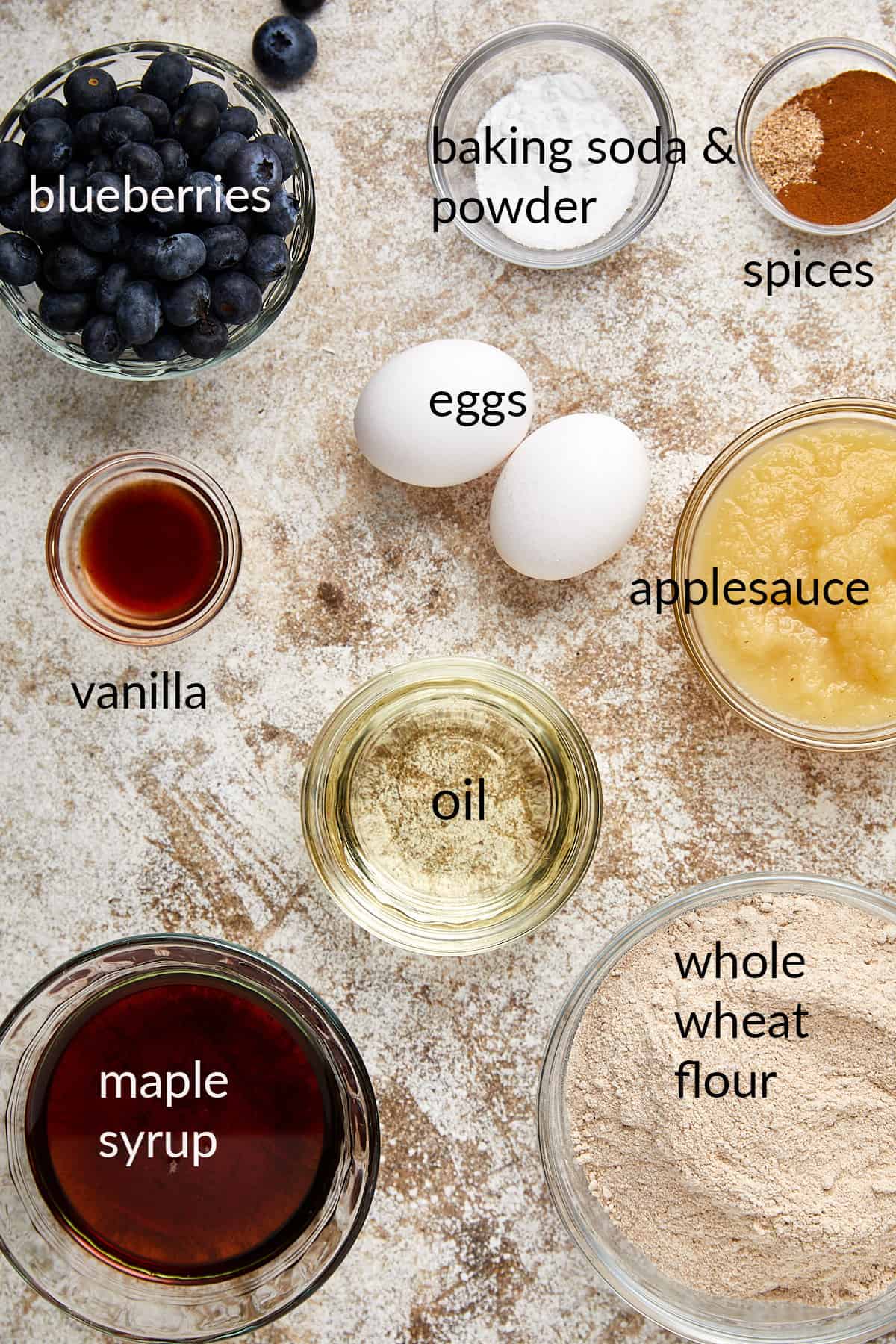 ingredients in glass bowls for healthy whole wheat blueberry muffins. 