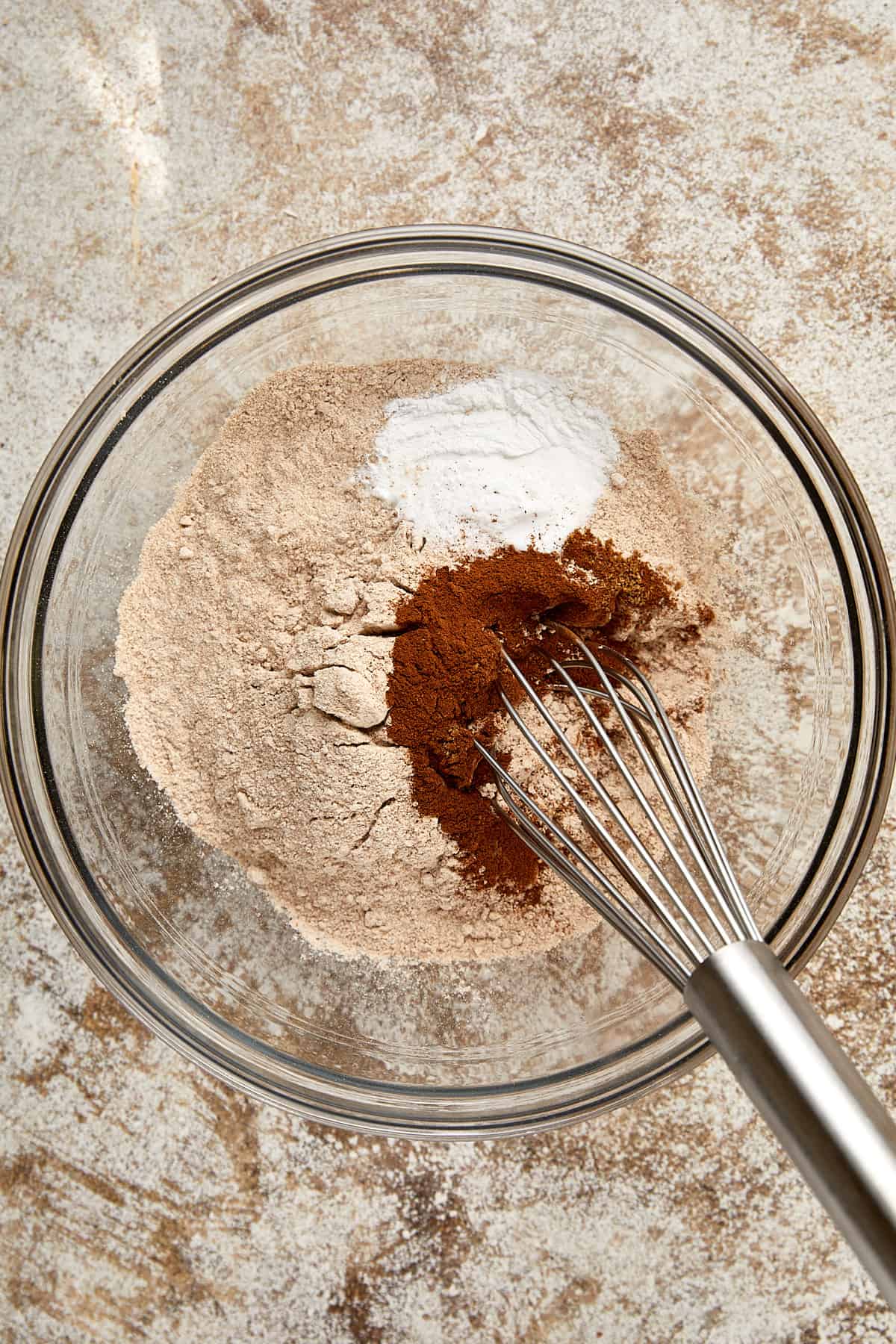 whole wheat flour, baking powder, baking soda, cinnamon, grated nutmeg, and coriander with a whisk.