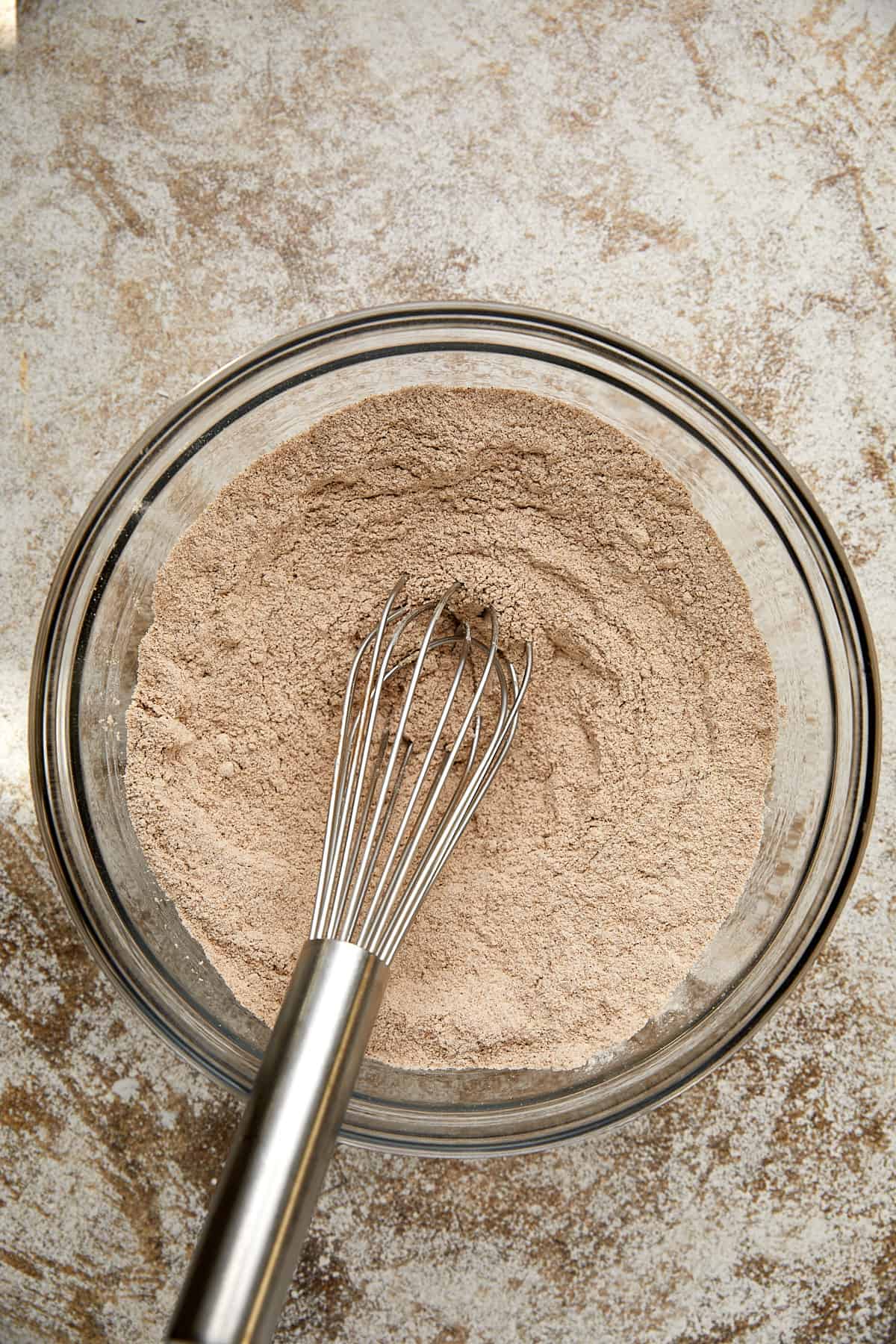 dry ingredients mixed with a whisk in a glass bowl.