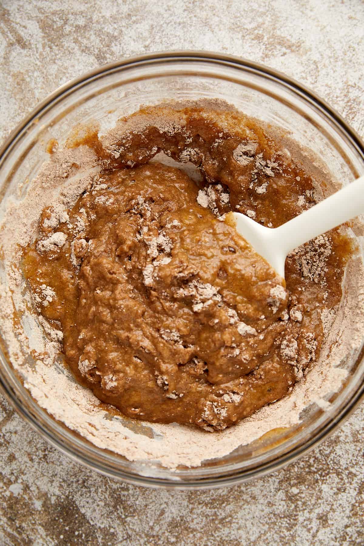 dry and wet ingredients mixed a few times with a spatula in glass bowl.