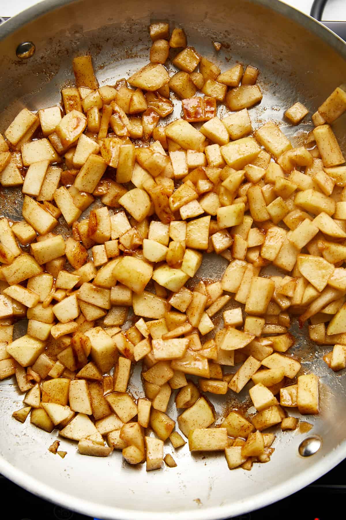 sautéed apples with butter, cinnamon, and brown sugar in a stainless steel pan.
