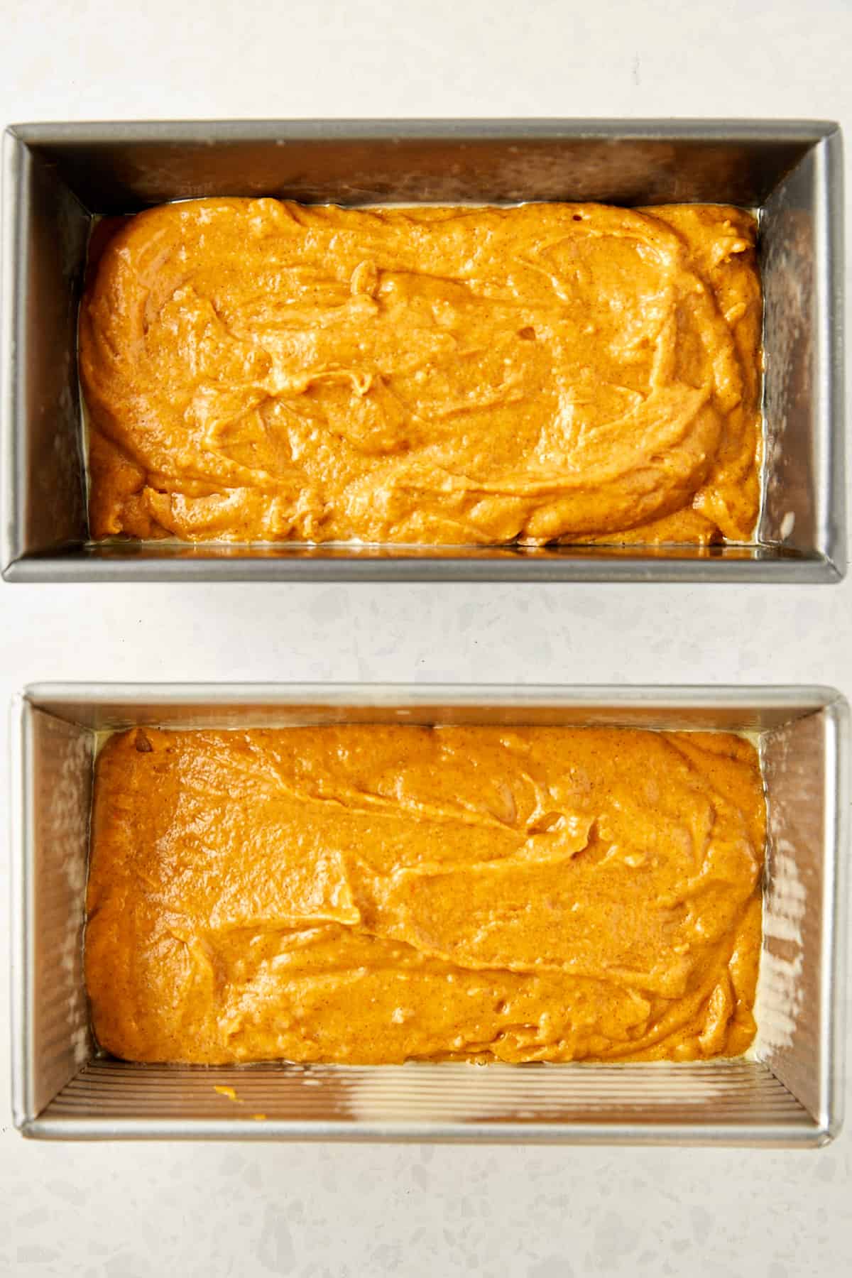 pumpkin bread batter in two prepared pans.