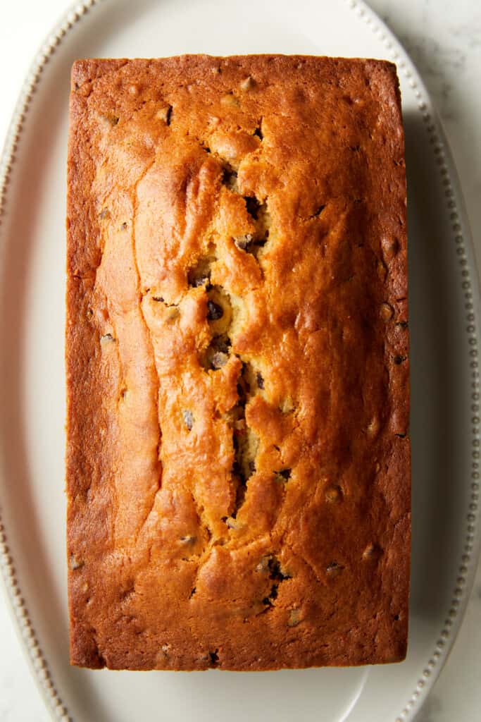 looking down at baked chocolate chip loaf cake on a white plate.