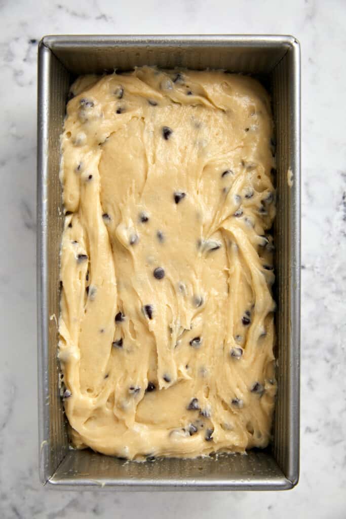 looking down at chocolate chip loaf batter poured into loaf pan.