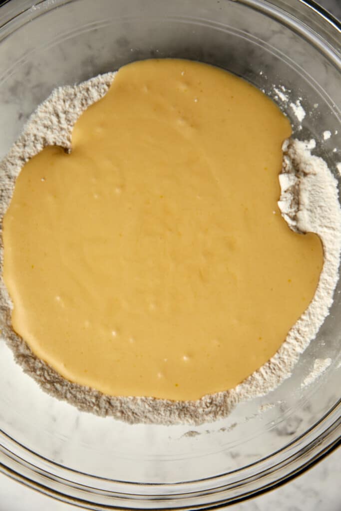 looking down at a glass bowl with the wet ingredients poured into dry ingredients.