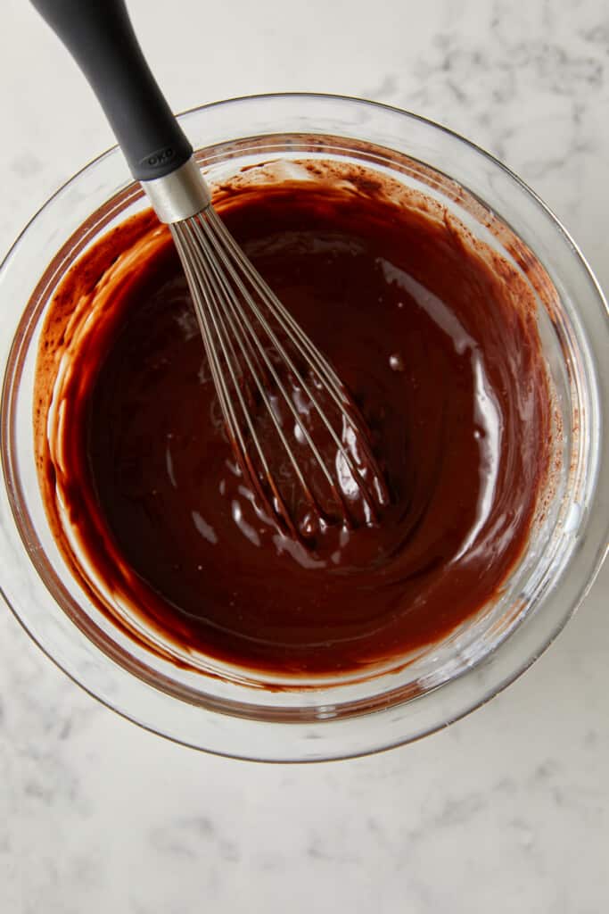 looking down at glass bowl with chocolate and cream mixed together.