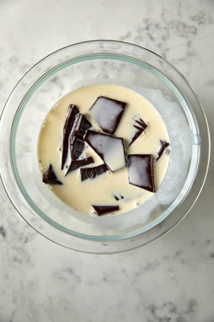 looking down at clear bowl with cream and chocolate.
