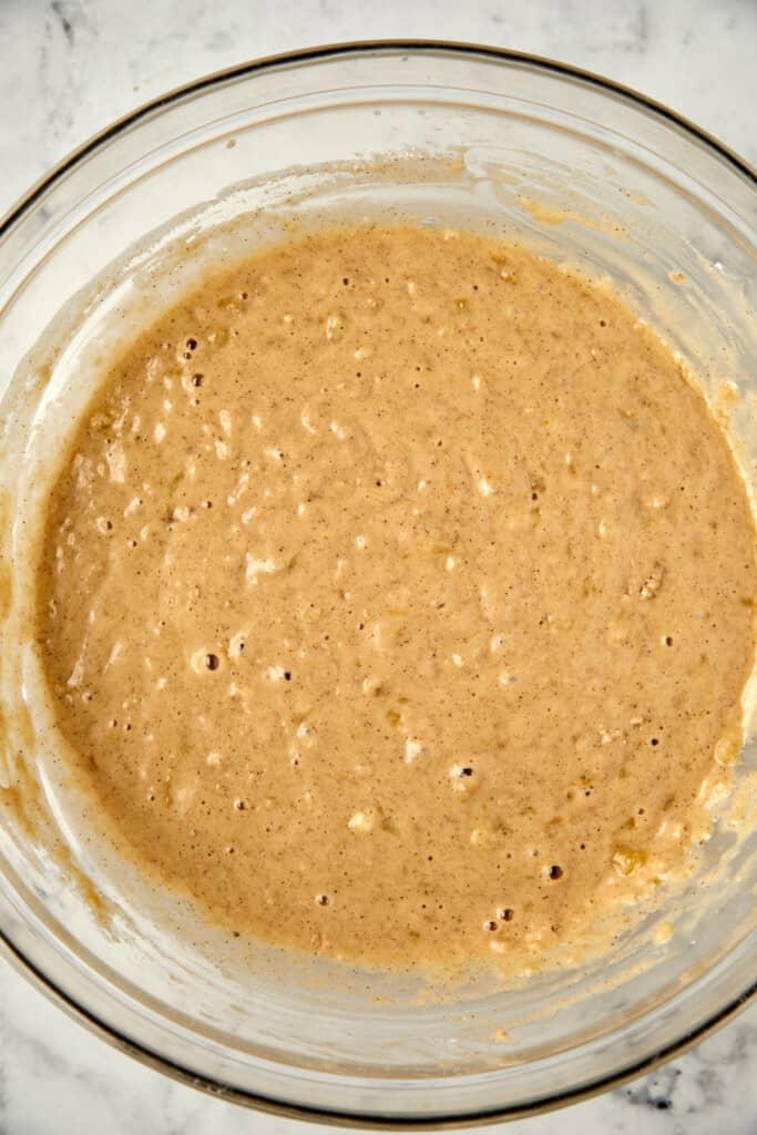 Looking down at banana bread with pecans wet ingredients.