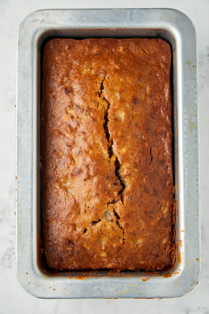 Looking down at banana bread with pecans baked in a loaf pan.