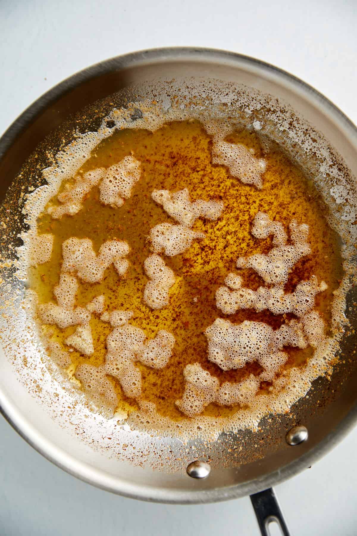 a stainless steel pan with browned butter.