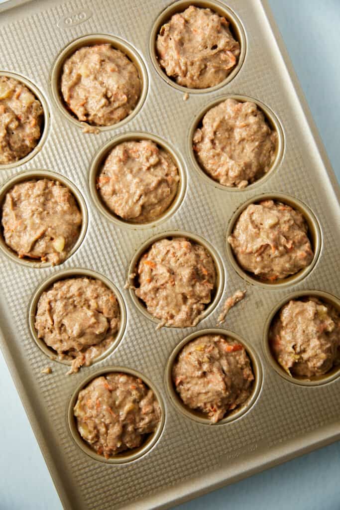raw batter fills the muffin cups in the muffin pan.