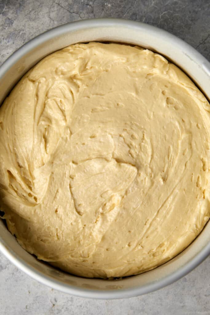 Looking down at the peach cobbler cake batter in the baking pan.