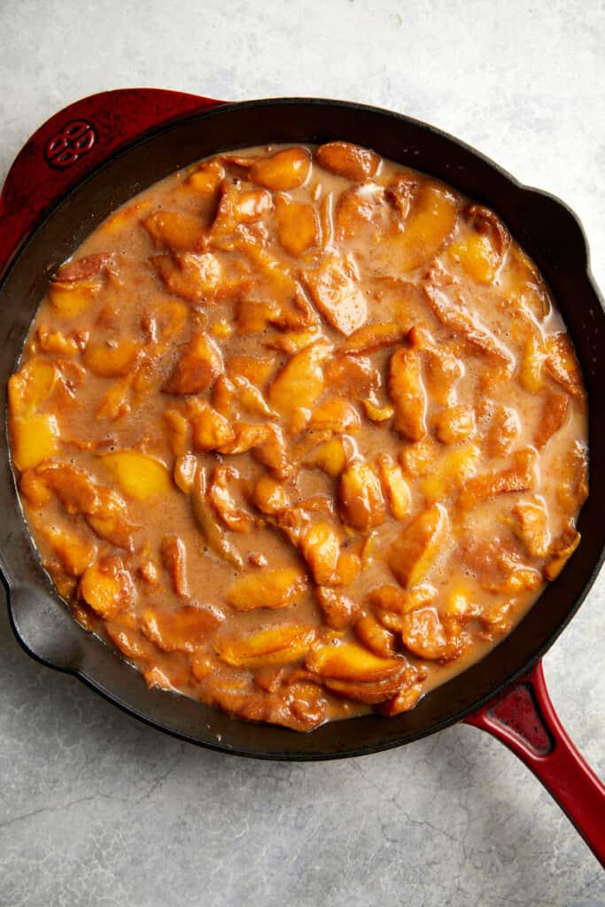 looking down at peaches in the cast iron pan prior to baking.