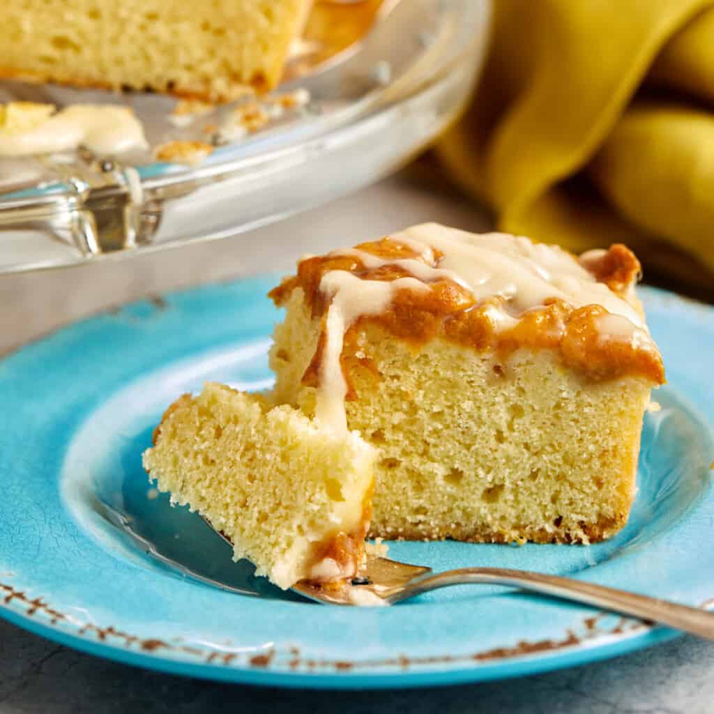close-up shot of a piece of cake on a blue plate with a piece of cake on a fork.