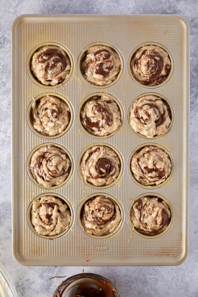 Overhead view of Nutella muffin batter with swirled Nutella.