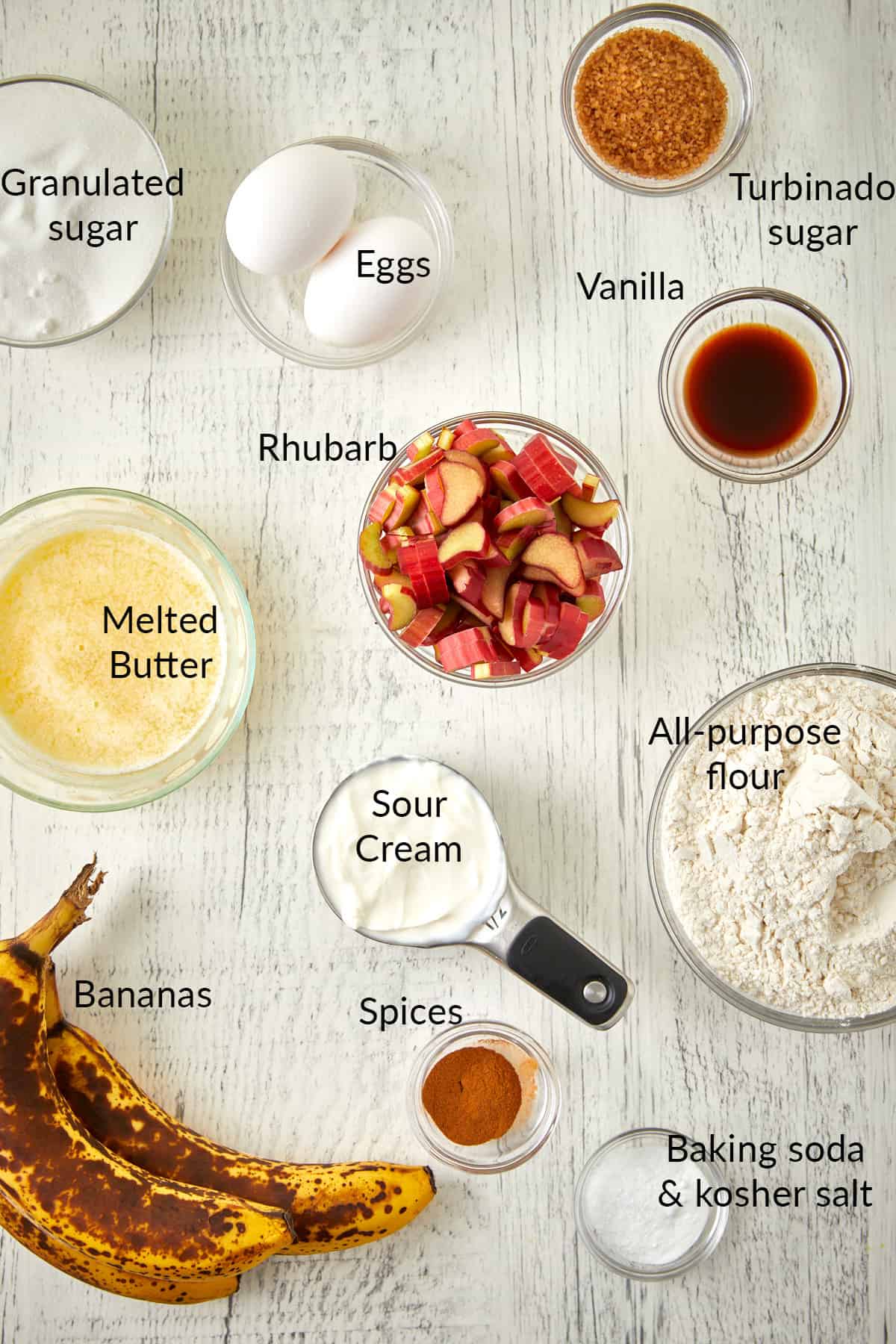 Overhead view of rhubarb banana bread ingredients in small bowls.