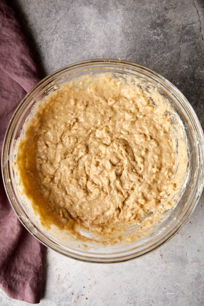 Overhead view of the wet and dry ingredients mixed together in a clear bowl.