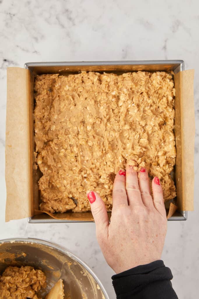 Overhead view of oatmeal crust pressed out in pan. 