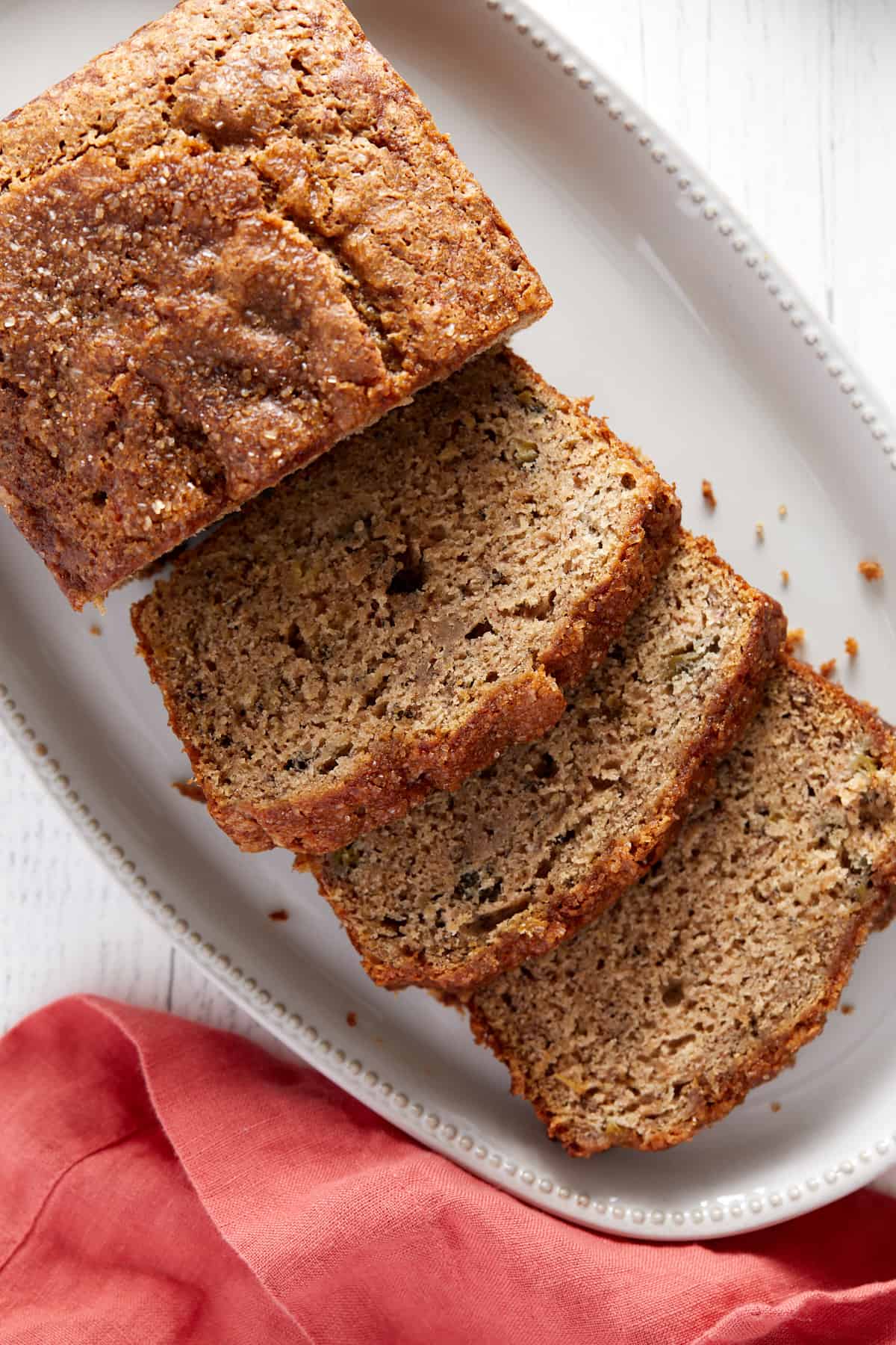 Overhead view of baked rhubarb banana bread slices on a white platter.