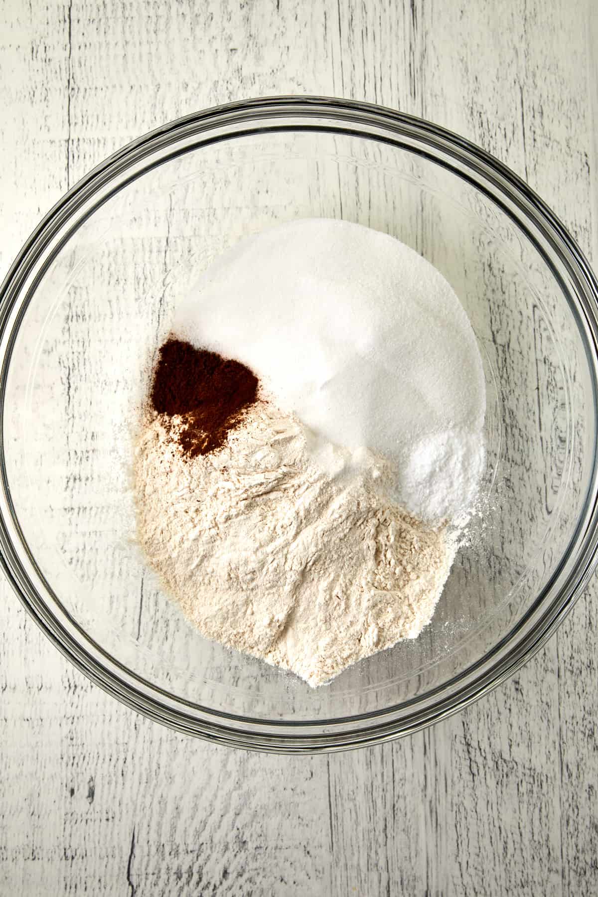 overhead dry ingredients piled into clear bowl