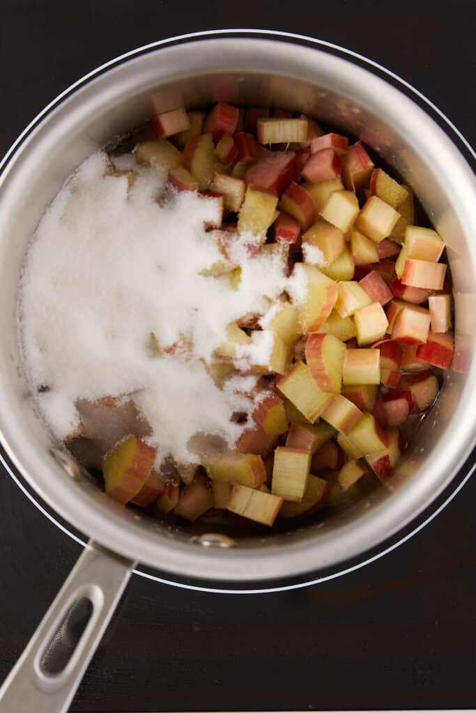 overhead view of chopped rhubarb and sugar in a saucepan.