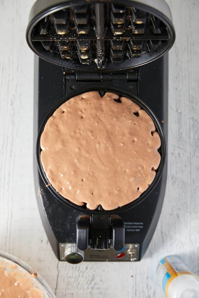 Overhead view of batter on waffle maker.
