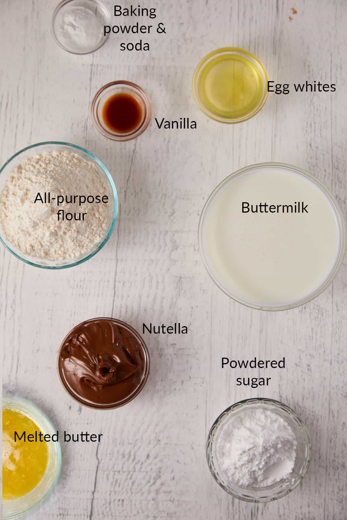 Overhead view of Nutella waffles ingredients in clear bowls.