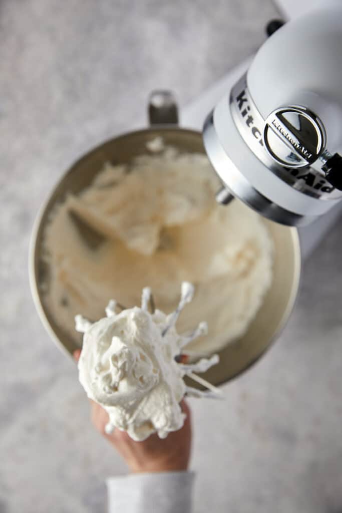 Overhead view of cream whipped on a whisk attachment to a stand mixer.