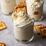 Close up view of banana pudding cups with whipped cream on top.