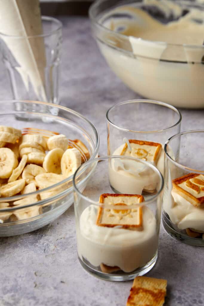 Cups with cookies on top of vanilla pudding layer. 