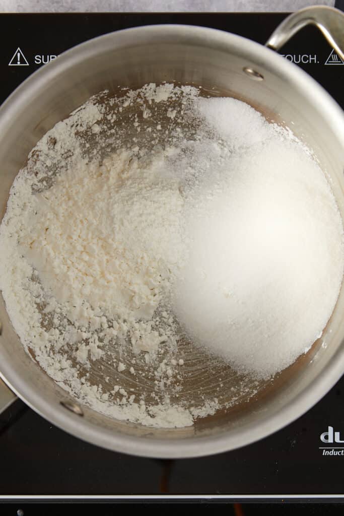 Overhead view of sugar, cornstarch, and salt in a saucepan. 