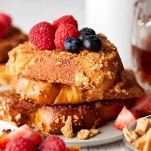 Close-up view of cinnamon toast crunch on a plate with fruit on top.