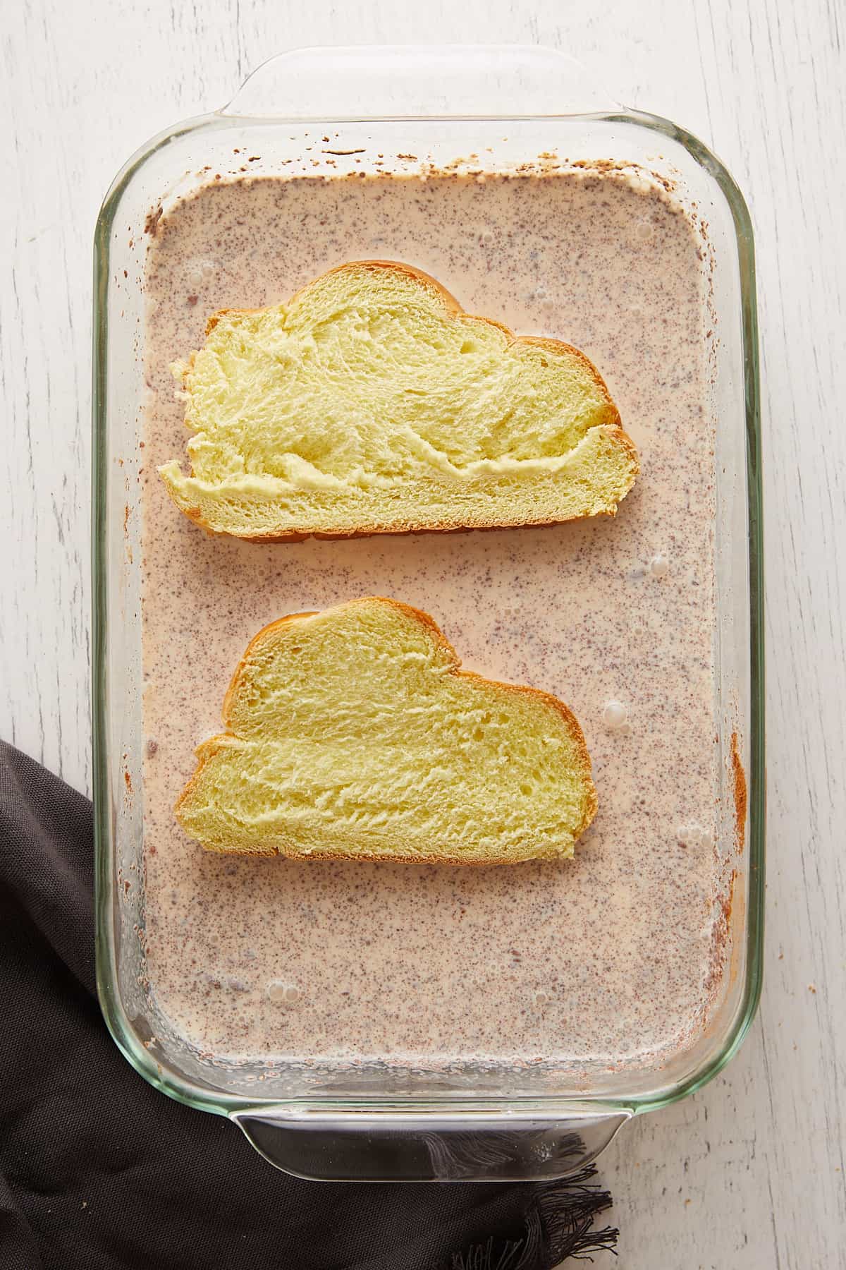 Overhead view challah bread in laying in the custard.