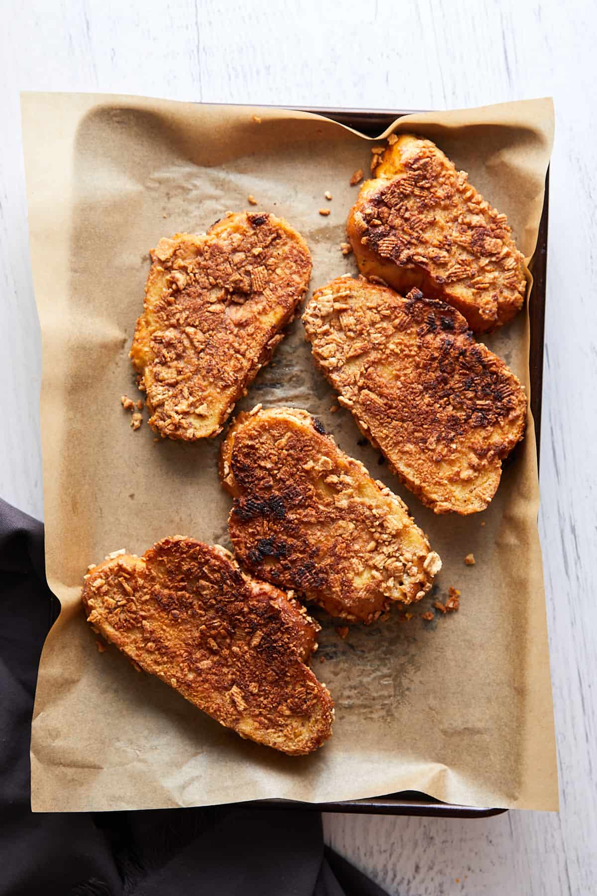 Cinnamon Toast crunch baked laying on parchment paper on a baking sheet.