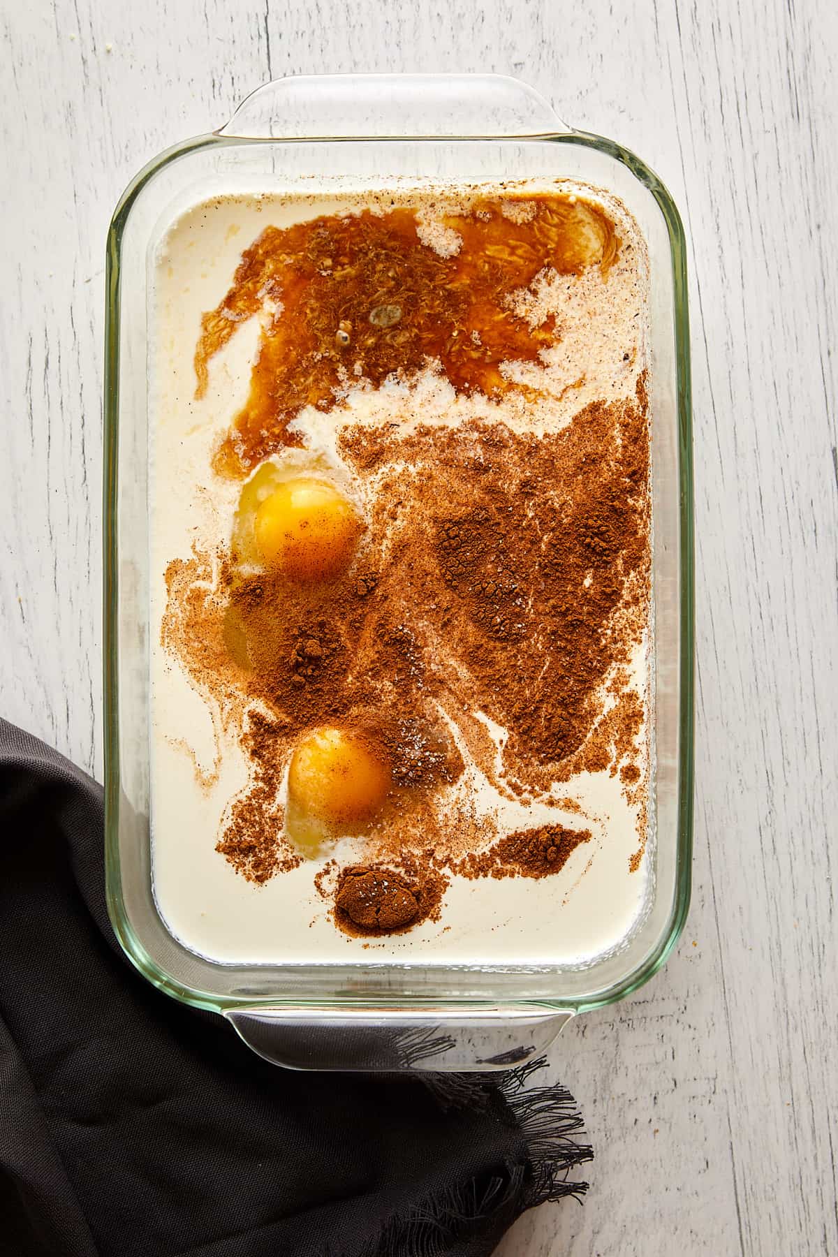 Overhead view Cinnamon Toast crunch custard ingredients in a shallow dish.