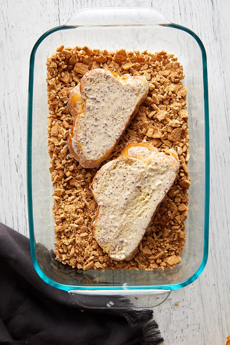 Overhead view of challah bread dipped into cinnamon toast crunch crumbles. 
