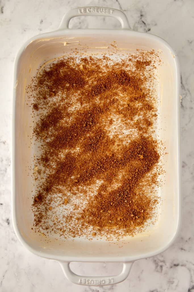 Overhead view of casserole dish with sugar and spice sprinkled on the bottom.