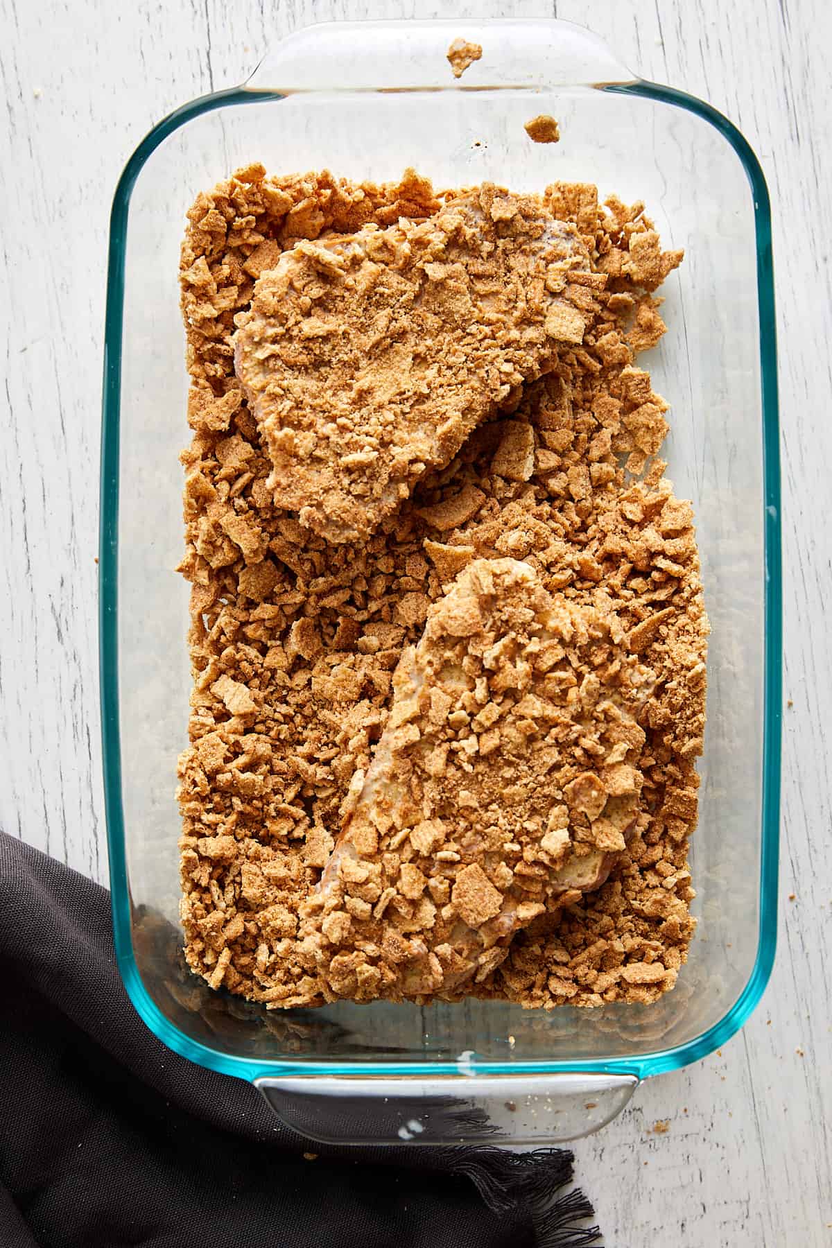 Overhead view of two pieces of challah bread coated with the cinnamon toast crunch crumbles. 