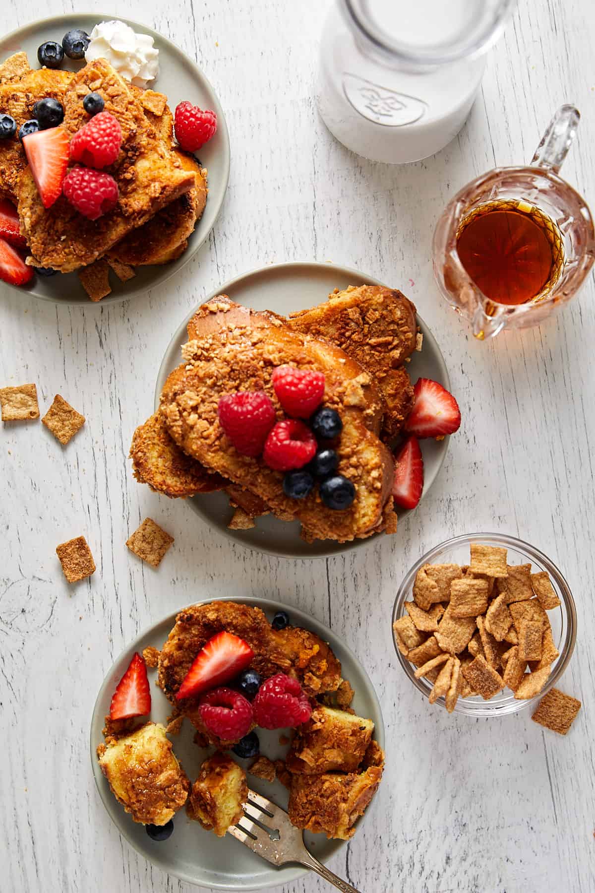 Overhead view of cinnamon toast crunch on plates with fruit on top.