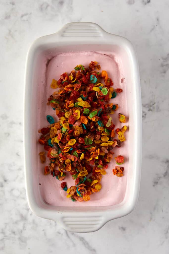 Overhead view of crunchy fruity pebble on top of ice cream.