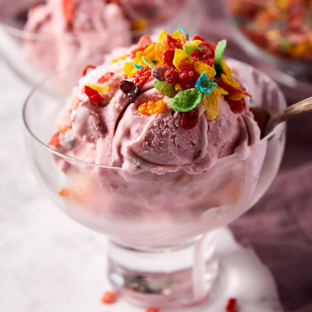 Fruity pebble ice cream in bowl with spoon.