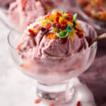 Fruity pebble ice cream in bowl with spoon.
