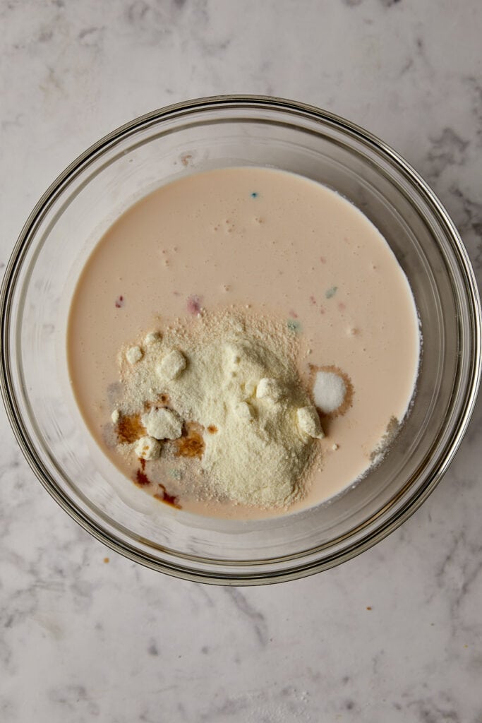 Overhead view of dry ingredients in fruity pebble milk.