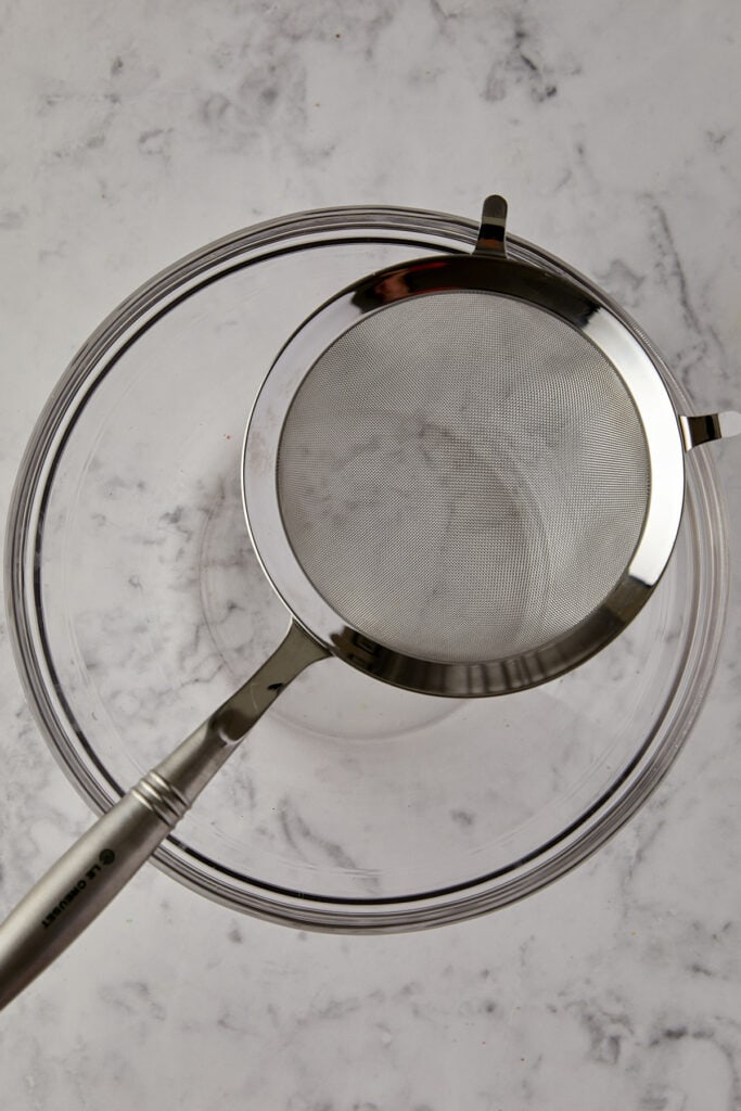 Sieve sitting on top of glass bowl