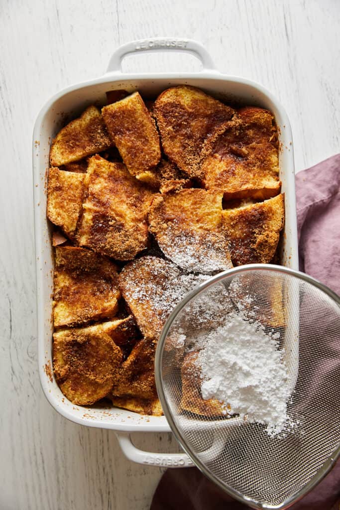 Overhead view of challah french toast casserole with powdered sugar sprinkled on top. 